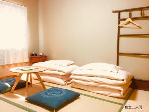 京都京都岚山宾馆的一间设有两张床和一张桌子的房间