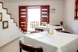 伊塔马拉卡Pousada Nossa Ilha的一间带两张桌子和楼梯的用餐室