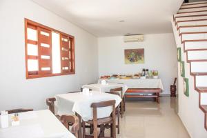伊塔马拉卡Pousada Nossa Ilha的一间设有两张桌子和窗户的用餐室