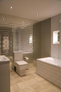 普雷斯顿普雷斯顿10号公寓式酒店的带浴缸、卫生间和浴缸的浴室。