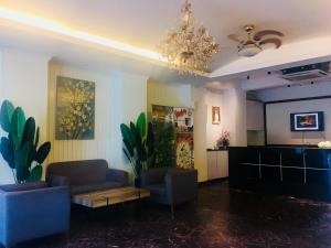 怡保东方大酒店的客厅配有两把椅子、一张沙发和一个吊灯。
