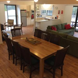 Barnes Bay布鲁尼艾奇达纳度假屋的用餐室以及带木桌和椅子的客厅。