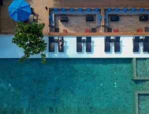 纳仲天U Pattaya的享有带椅子和遮阳伞的游泳池的上方景致