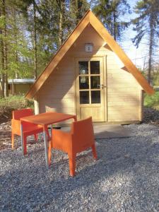 于尔克Vakantiepark 't Urkerbos - Kabouterhuisje的小屋前方设有桌椅