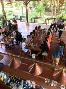 Amphoe Sawang Daen Din查塔帕雅度假村的一群坐在餐厅桌子上的人