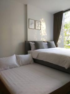 Ban Huai Sok NoiThe Valley Khao Yai-2 Bed Room的一间卧室设有两张床和窗户。