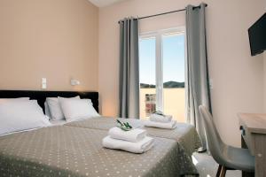 卡西奥皮Artheo Hotel的一间卧室设有两张床、一张桌子和一个窗口。