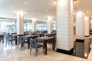 美洲海滩尔卡诺春天酒店的用餐室设有桌椅和窗户。