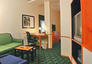 布伦瑞克不伦瑞克费尔菲尔德套房客栈的酒店客房设有绿色沙发和书桌