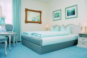 哈尔伯格摩斯丹尼尔斯酒店的一间卧室配有一张床、一张桌子和一面镜子