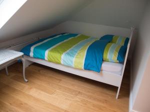 不莱梅Schönes Studio zentral的铺有木地板,配有带彩色床单的白色双层床