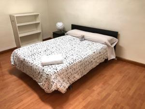 萨拉曼卡托莱克拉维洛公寓的一间卧室配有一张带黑白毯子的床