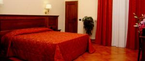 佛罗伦萨加州酒店的一间卧室配有红色的床和红色窗帘