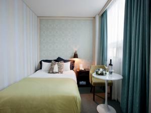 首尔中央观光酒店的一间卧室配有一张床、一张桌子和一个窗户。