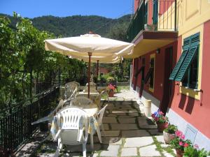 佐阿利Affittacamere Cerisola 2003的庭院配有桌椅和遮阳伞。