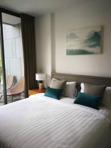 Ban Huai Sok NoiThe Valley Khao Yai-2 Bed Room的卧室配有带蓝色枕头的大型白色床