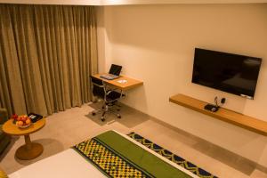 蒂鲁内尔维利Regency Tirunelveli By GRT Hotels的客厅配有笔记本电脑、书桌和电视