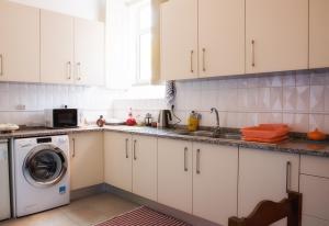科英布拉橄榄街公寓的厨房配有白色橱柜和洗衣机。