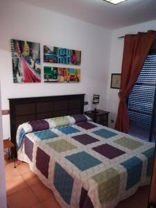 阿尔姆尼卡Bahía Santa Cruz的一间卧室配有床,床上装有被子