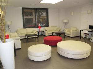格拉纳达唐璜酒店的一间设有白色沙发和桌子的等候室