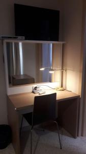 拉巴特Estrella Lodging的一张带台灯、镜子和椅子的桌子