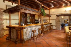 卡里翁德洛斯孔德斯Hotel Real Monasterio de San Zoilo的砖墙餐厅里的酒吧