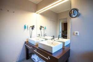 朗格奥芮秋设计酒店的一间带三个水槽和大镜子的浴室