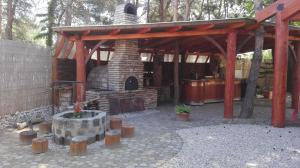 凯奇凯梅特凯奇凯梅特桧柏公园酒店的一个带石头壁炉和木制凉亭的庭院