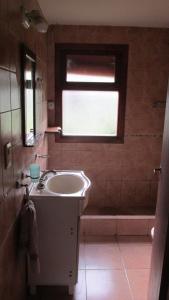普埃洛湖Cabañas Peñi Huen的一间带水槽和浴缸的浴室以及窗户。