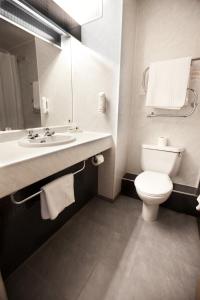 斯温斯黑德Supreme Inns Boston的一间带卫生间、水槽和镜子的浴室