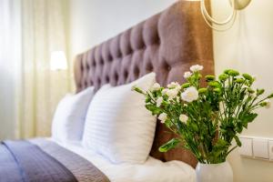 帕兰加Vila Elegancija的一张带白色枕头的床和花瓶