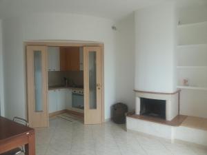 奥斯图尼Attico Ostuni的厨房设有一扇门,可通往带壁炉的房间