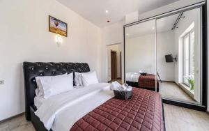 敖德萨Hotel Sorrento的一间卧室设有一张大床和一个大镜子