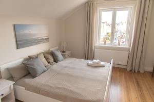 吕贝克Apartment Stadtblick的白色的卧室设有一张大床和一个窗户