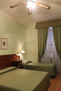 罗马费欧瑞酒店的酒店客房配有两张床和吊扇。