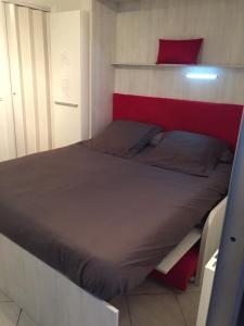 卢贝新城Residence Acapulco的一间卧室配有一张红色和白色床头板的床