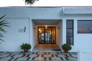 维拉摩拉多高尔菲公寓酒店的通往两座盆栽植物建筑的门