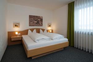普夫龙滕普夫龙滕阿尔卑斯酒店的卧室配有带白色枕头的大床
