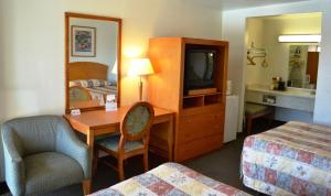 弗雷斯诺弗雷斯诺哇卡班德客栈的酒店客房设有带书桌和电视的卧室。
