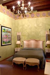 维罗纳Villa della Torre in Città的一间卧室配有一张带两把椅子的床和吊灯。