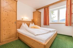 米特西尔阿尔卑斯霍夫公寓酒店的一间卧室设有一张大床和窗户