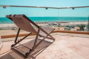 北马马亚-讷沃达里Nautic Luxury Club的海滩景阳台的椅子