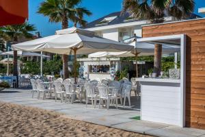 滨海弗兰卡维拉阿尔贝各普恩塔东酒店的海滩上的一组椅子和遮阳伞