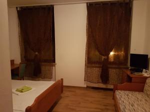 普福尔茨海姆拉姆酒店的一间卧室设有两张床和两个窗帘的窗户。