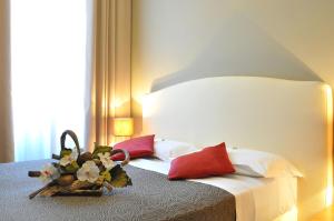 热那亚新诺德酒店的一间卧室配有红色和白色枕头的床