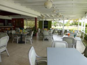 布里奇敦Rockley Golf Club, 2 bed 2 bath Pool, Tennis, Golf, Bar & Restaurant!的一间带桌椅的餐厅