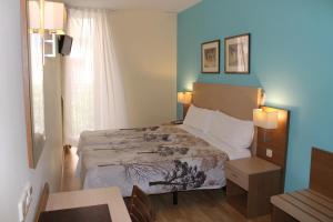 马德里太阳门米拉多酒店的一间卧室配有一张床、一张桌子和一个窗户。