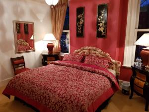 多切斯特贝格斯山丘酒店的红色卧室配有一张红色床罩的床