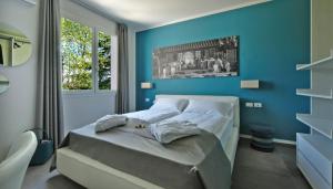 拉齐塞Relais Villa Clodia的一间卧室配有一张蓝色墙壁的床