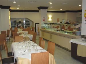 格拉纳达唐璜酒店的餐厅设有白色的桌椅和柜台